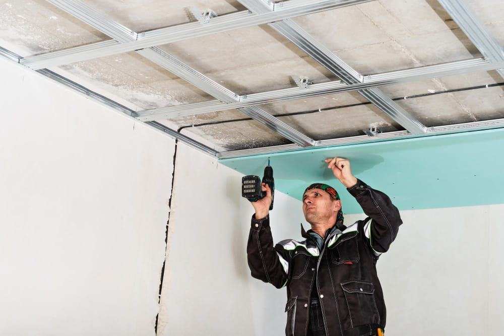 Restoration team repairing water-damaged drywall and flooring